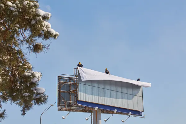 Montaż siatki reklamowej na billboardzie